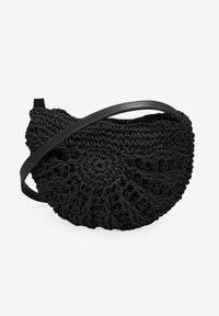 Bolso de ganchillo negro con forma circular, tejido texturizado y una correa de cuero negra. Presenta un diseño en espiral en la parte frontal.