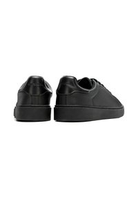 Sneakers in pelle nera con finitura testurizzata, suole in gomma piatte e design minimalista. Presentano un logo impresso sul tallone.