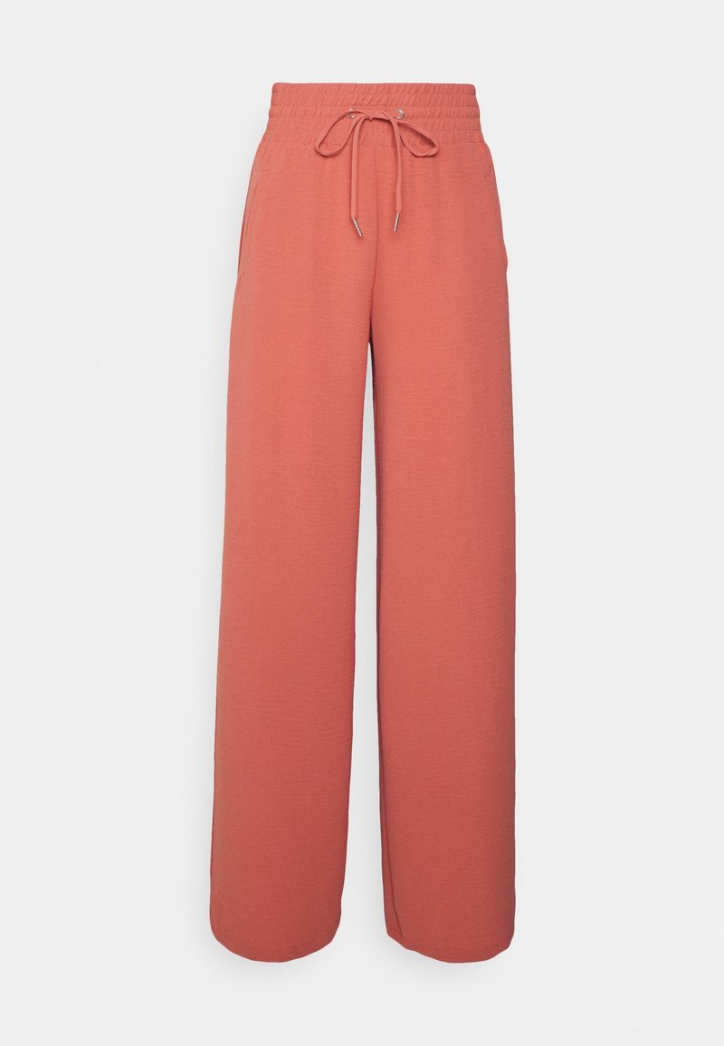 Pantalon ample à taille haute couleur corail, jambes larges, doté d'une ceinture élastique et d'un cordon de serrage à l'avant sur un fond uni.