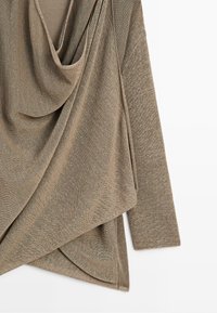 Cardigan en tricot marron clair avec devant ouvert drapé et manches longues, présenté à plat sur fond blanc.