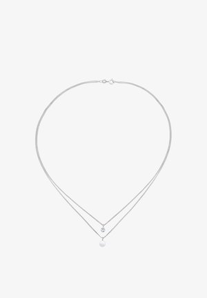 Srebrny podwójny naszyjnik z okrągłym wisiorkiem i małym akcentem w postaci kryształu, z delikatnym wzorem łańcuszka.