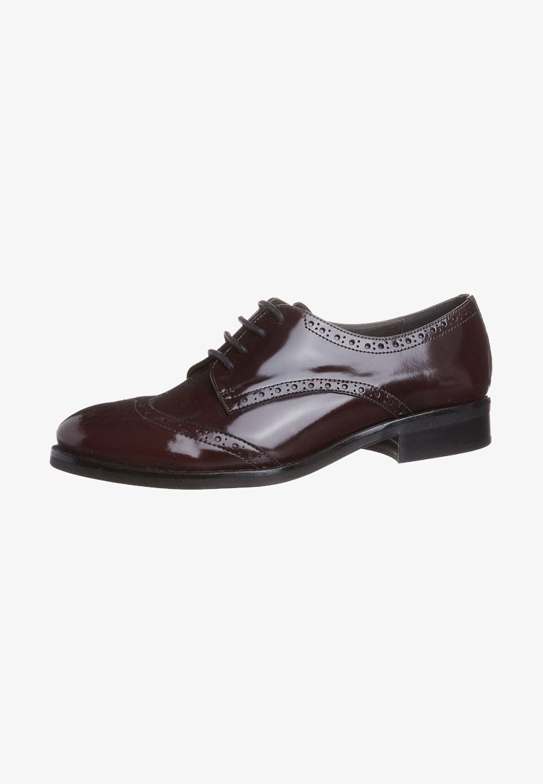 Chaussure Oxford en cuir poli brun foncé avec détails brogue et lacets noirs, talon bas et bout arrondi.