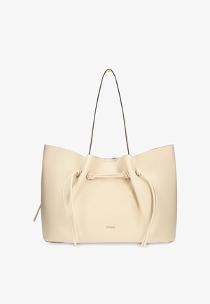 Sac fourre-tout en cuir couleur crème avec fines bretelles et un cordon à l'avant avec des nœuds.