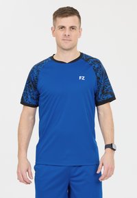 Blå sporttröja med kontrasterande svarta mönstrade ärmar, kortärmad, v-ringad design och tryckt "FZ"-logotyp på framsidan.
