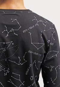 Black fabric long-sleeve shirt featuring white mathematical graphics and equations printed in various line styles across the surface.