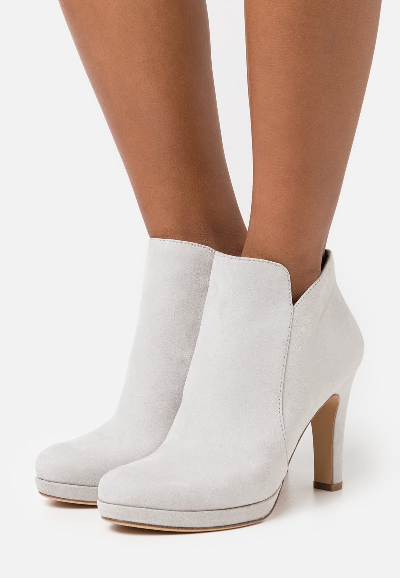 Gray suede ankle boots with a rounded toe, featuring a side cutout design and a slim, high heel. Smooth texture and minimalist style.