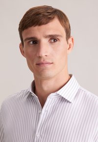 Camicia a righe lilla e bianca con colletto button-down, caratterizzata da una texture di tessuto liscia e piccoli bottoni sul davanti.