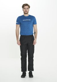 Blå sportt-shirt med en strukturerad mönster och "ENDURANCE" logotyp, ihop med svarta joggarbyxor med elastisk midja och svarta sportskor.