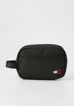 Beauty case in nylon nero con chiusura a zip, dotato di una tasca frontale e una maniglia in tessuto. Toppa con logo visibile sul lato.