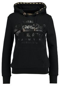 Felpa nera con cappuccio realizzata in un misto cotone. Presenta lacci con accessori in oro, testo grafico, tasca frontale e polsini e orlo a coste.