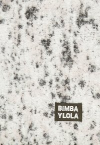 Tkany materiał w białym kolorze z szarymi kropkami, z zieloną metką, na której białymi literami napisano "BIMBA YLOLA".