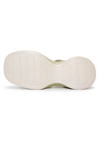 Skosula i ett strukturerat, ljust beige gummimaterial. Har en rundad form och horisontella spår för grepp.