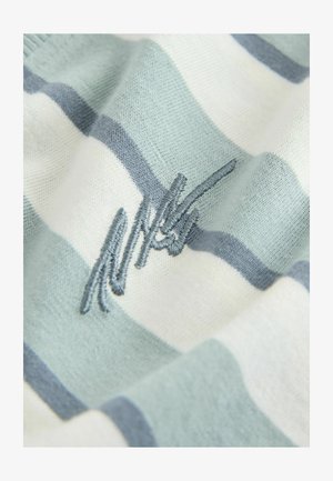 Tessuto a righe con colori alternati azzurro chiaro e bianco. Logo ricamato in filo blu sulla superficie del tessuto. Texture morbida.