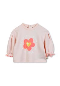 Haut en coton rose avec des manches bouffantes, présentant un motif floral et un cœur en sequins. Texte "aime chaque jour" disposé en cercle.