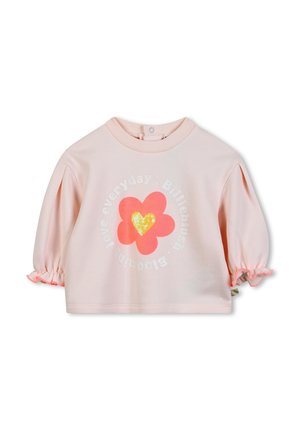 Haut en coton rose avec des manches bouffantes, présentant un motif floral et un cœur en sequins. Texte "aime chaque jour" disposé en cercle.