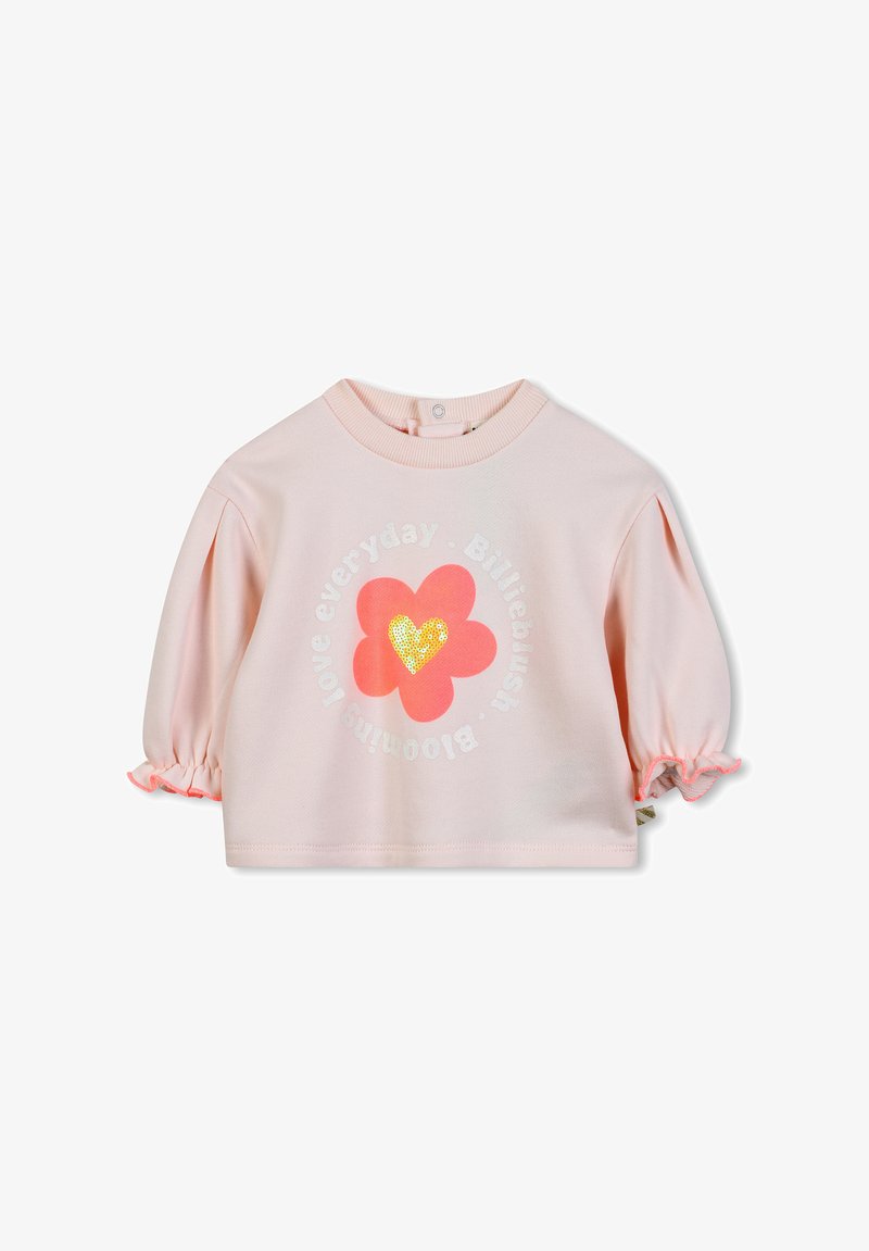 Haut en coton rose avec des manches bouffantes, présentant un motif floral et un cœur en sequins. Texte "aime chaque jour" disposé en cercle.