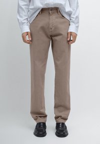 Beżowe spodnie straight-leg wykonane z bawełny, z klasycznym pięciopocketowym wzorem, zapięciem na guzik oraz subtelnymi detalami w postaci przeszyć.