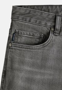 Grijze denim jeans met een gladde textuur, voorzien van een standaard tailleband, een voorzak met etiket en een metalen knoopdetail.