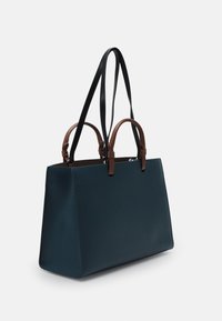 Mörk teal totebag med en strukturerad form, tillverkad av texturerat material. Utrustad med bruna läderdetaljer och två svarta bärremmar.