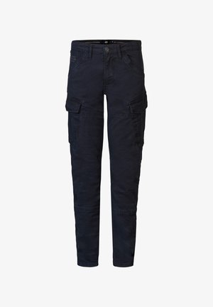 Niebieska bawełniana koszulka z krótkim rękawem, zestawiona z ciemnymi spodniami cargo. Noszona z białymi trampkami z czarnymi akcentami.