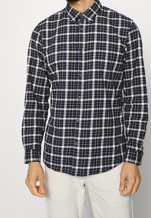 Button-up shirt in navy and white plaid pattern, made of cotton, featuring a classic collar and long sleeves.