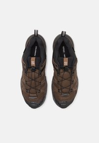 Brązowe buty trekkingowe z siateczki i syntetycznego materiału z czarnymi akcentami. Posiadają teksturowany design, bezpieczny system sznurowania oraz wyściełane wnętrze.