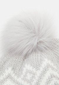Bonnet en tricot gris avec un grand pompon en fausse fourrure grise claire et douce sur le dessus, présentant un motif texturé dans une teinte de gris plus clair.