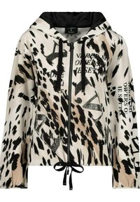 Veste à capuche zippée beige clair avec imprimé animalier noir et texte. Dotée de cordons de serrage et d'une doublure noire. Texture douce avec une coupe décontractée.