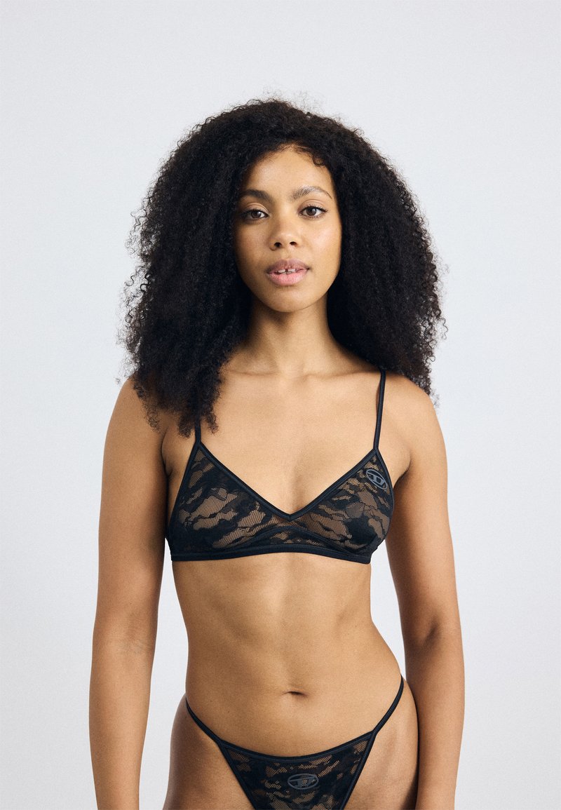 Zwart kanten lingerieset met een diepe bralette met dunne bandjes en bijpassende string. Transparant bloemenpatroon met contrasterende zwarte rand.