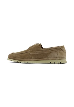 Lichtbruine suède casual veterschoen met beige rubberen zool, zijstiksels en moc toe ontwerp, getoond in zijaanzicht op witte achtergrond.