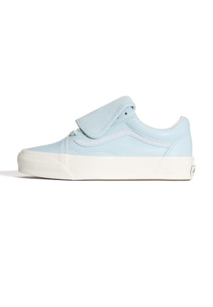 Zapatilla de lona azul claro con lengüeta acolchada, suela de goma blanca y diseño minimalista. Presenta detalles cosidos y una silueta sencilla.