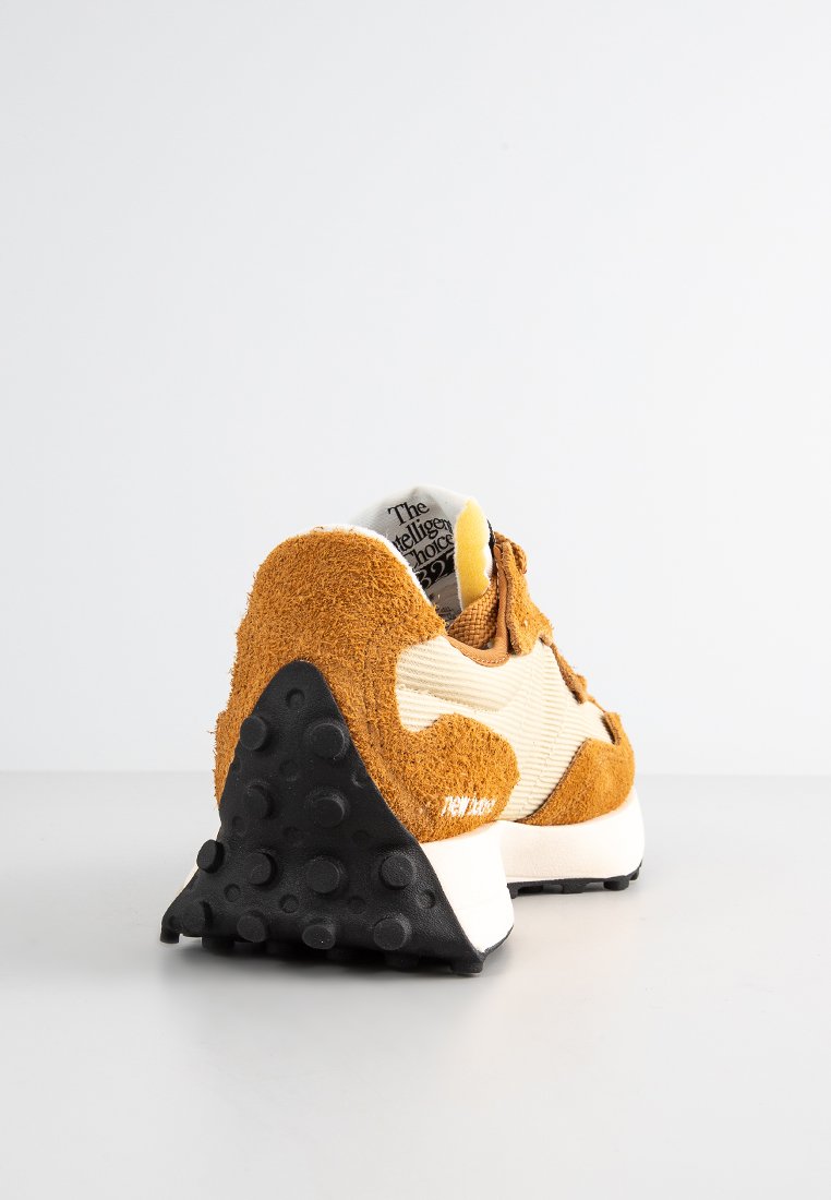 Sneaker mit einem Obermaterial aus braunem Wildleder und cremefarbenen Stoffdetails. Verfügt über eine strukturierte schwarze Sohle und ein bedrucktes Etikett an der Ferse.