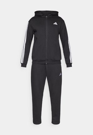 Sort atletisk træningsdragt lavet af blødt stof; hættetrøje med lynlås og hvide striber på ærmerne samt logo på brystet; matchende tilspidsede bukser med logo.