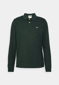 Long-sleeve polo shirt in dark green, made of cotton. Features a classic collar, two buttons, and a small embroidered logo on the chest.