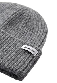 Grå ribbet strikket beanie-hat lavet af uld, med et hvidt stofmærke med "Resteröds" i sort tekst. Teksturert, varm design.