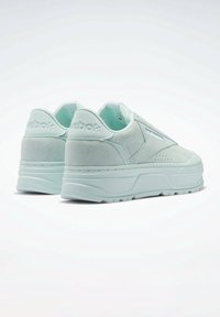 Miętowo-zielone sneakersy z zamszowej cholewki, grubą platformą i teksturowanymi akcentami. Logo na pięcie. Płaskie sznurowadła i wyściełany kołnierz.