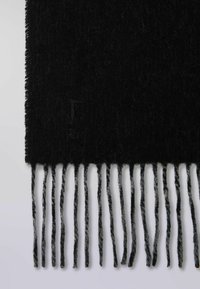 Bufanda de lana negra con acabado texturizado, con largas borlas alternas en negro y gris. Logo sutil de la marca grabado en un extremo.