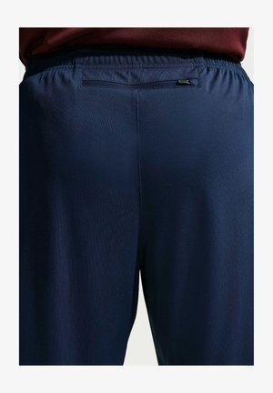 Pantaloni sportivi blu navy con finitura testurizzata e cintura elastica. Presentano una piccola tasca con cerniera sul retro.