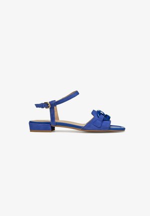 Sanda de ante azul con puntera cerrada, tira en el tobillo y tacón bajo. Presenta un lazo decorativo y una plantilla suave de contraste.