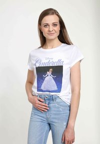 Hvid bomulds T-shirt med et graphic af Askepot i en blå kjole, med lilla tekst der står "Disney Askepot," parret med lyseblå jeans.