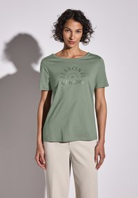 Světle zelené bavlněné tričko s kulatým výstřihem a krátkými rukávy, s potiskem designu "Sezónní barvy" ve tmavším odstínu.