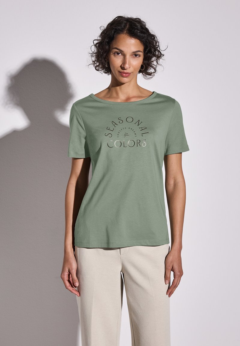 Světle zelené bavlněné tričko s kulatým výstřihem a krátkými rukávy, s potiskem designu "Sezónní barvy" ve tmavším odstínu.