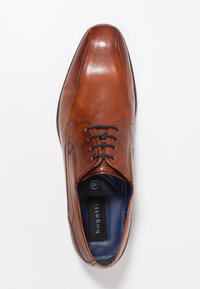 Chaussure habillée en cuir marron avec une finition lisse, bout arrondi, design à lacets et doublure intérieure bleu marine. Logo "Bugatti" visible sur la semelle.