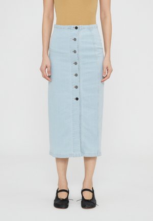 Hele sinine denim midi seelik sirge lõikega, ees nupuvajutusega ja toore servaga. Kanda mustade ümmarguse ninaga kingadega.
