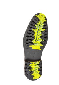 Semelle en caoutchouc noir avec des accents jaunes, présentant un motif de bande de roulement texturé ressemblant à un feuillage et des rainures pour l'adh érence. Taille 7 indiquée.