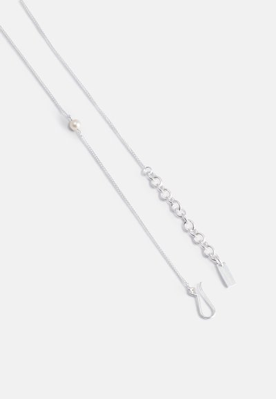 Ασημένια αλυσίδα περιδέραιο που διαθέτει μια κεντρική πέρλα, με έναν συνδυασμό λεπτών συνδέσμων και μια μικρή ορθογώνια ετικέτα. Απλός σχεδιασμός με λεία υφή.