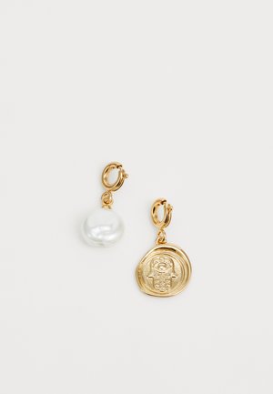 Gold hoop earrings featuring a white pearl and a textured round pendant with a design in relief, showcasing varying materials and finishes.