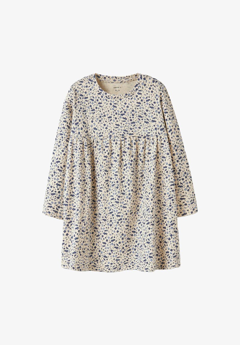 Robe à manches longues en coton beige clair avec un motif floral bleu. Dotée d'une taille froncée et d'un col rond.
