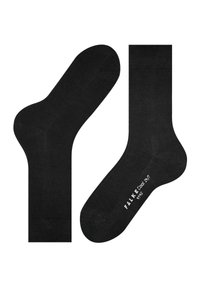 Calzini neri alla caviglia con texture liscia, caratterizzati da punte e talloni rinforzati. Logo stampato sulla suola, design minimalista.