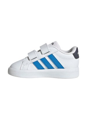 Zapatilla blanca con dos rayas azules y dos correas de velcro, diseño de tobillo bajo y una pestaña trasera negra con texto blanco.